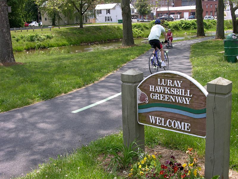 Luray Hawsksbill Greenway Welcome Sign with biker and lady on wheelchair