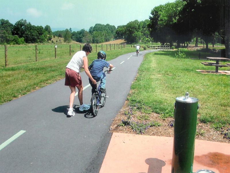 boy learning to ride a bike on the greenway